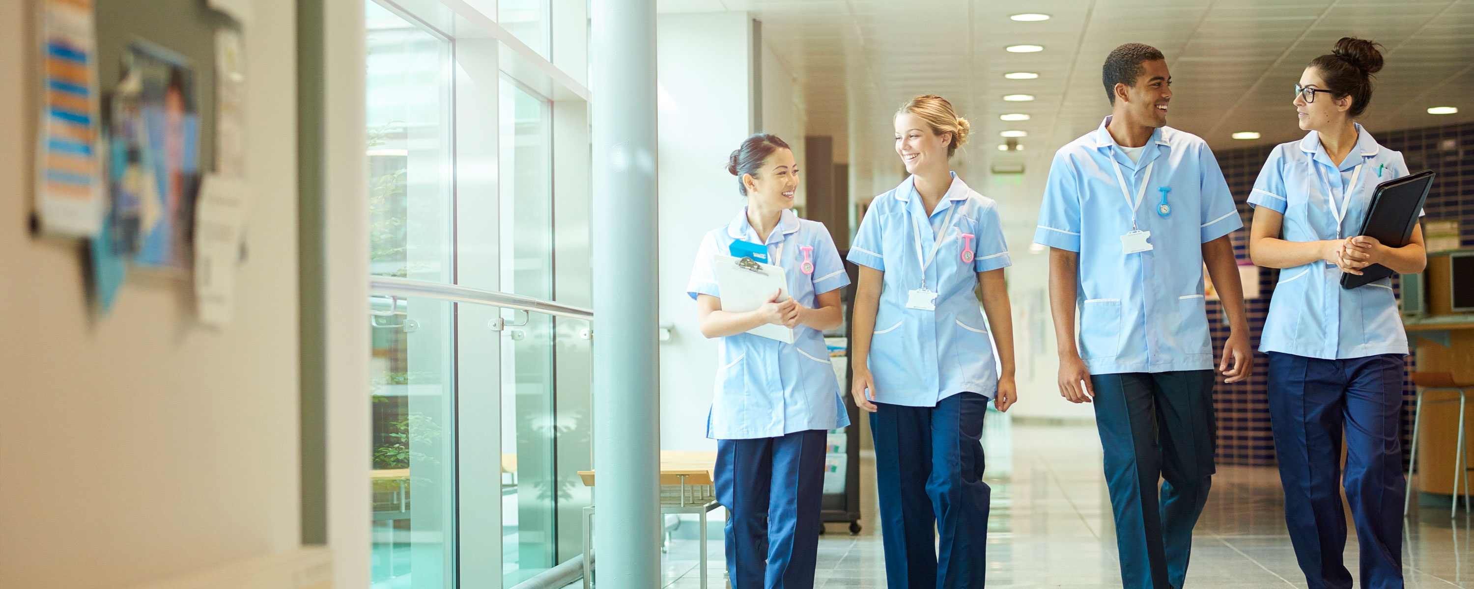 Four nurses walking down a corridor Four nurses walking down a corridor